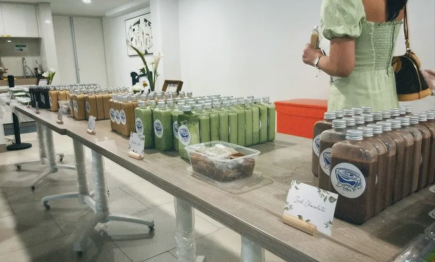 A long table of Brewprint bottled coffee and matcha door gifts at a wedding, arranged in rows by drink