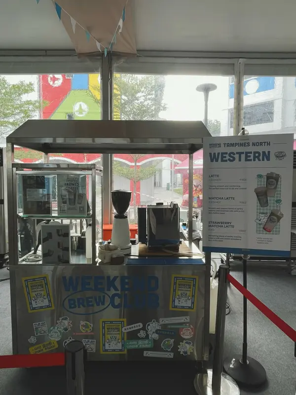 The Weekend Brew Club coffee cart with espresso machine and grinder, and a menu board listing latte, matcha latte and strawberry matcha latte